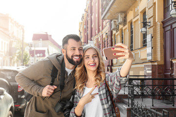 Fototapeta premium Happy young tourists taking selfie outdoors