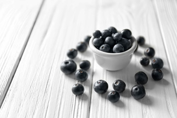 Bowl with fresh acai berries on wooden table