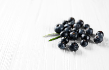 Fresh acai berries on wooden table, closeup