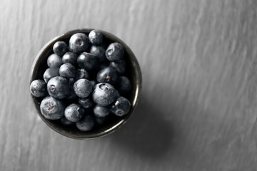 Bowl with fresh acai berries on table, closeup