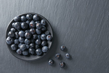 Plate with fresh acai berries on table