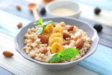 Nutritious oatmeal with banana and almonds on table