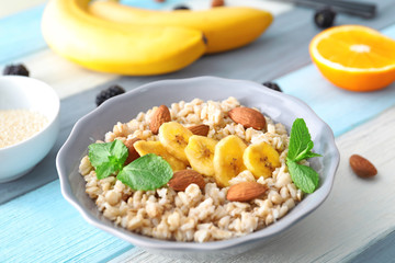 Nutritious oatmeal with banana and almonds on table