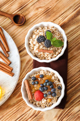 Tasty oatmeal with berries in bowls on table