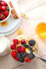 Tasty oatmeal with berries in jar on table