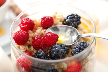 Tasty oatmeal with berries in jar on table, close up