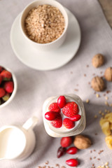 Nutritious oatmeal with berries and milk in jar on table