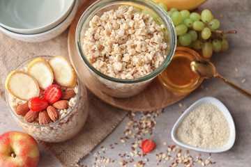 Jar and glass with tasty oatmeal on table