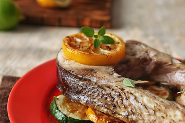 Red plate with fried fish steak, closeup