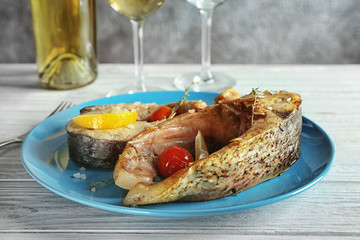 Ceramic plate with fried fish steaks on table