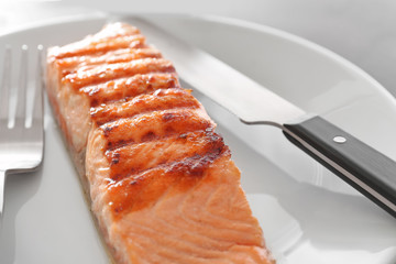 Slice of delicious salmon on plate, close up