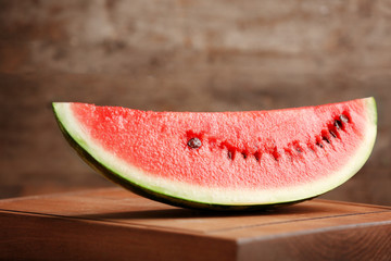 Slice of ripe watermelon on wooden board