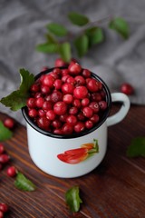 Fresh red cranberries with leaves on the table 