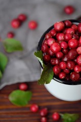 Fresh red cranberries with leaves on the table 