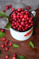 Fresh red cranberries with leaves on the table 