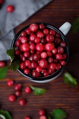 Fresh red cranberries with leaves on the table 