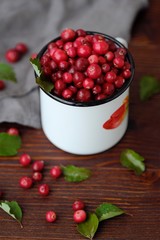 Fresh red cranberries with leaves on the table 