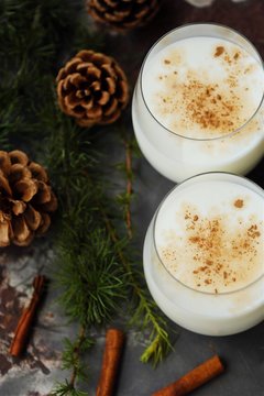 Delicious milkshake with cinnamon and pine on the table 