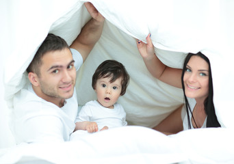 Happy young family with one child having fun together