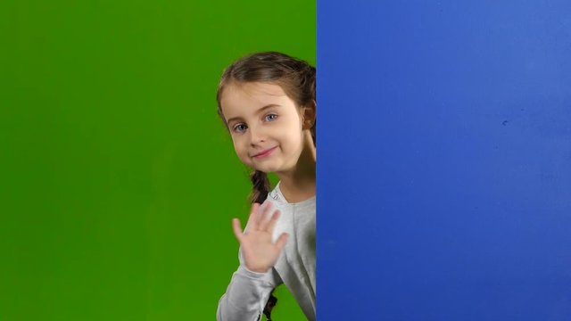 Child looks out from behind an empty board. Green screen
