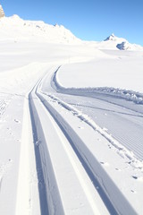 SKI TRACE IN SNOW COVERED MOUNTAIN LANDSCAPE