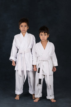 two boys of the karateka in a white kimono stand