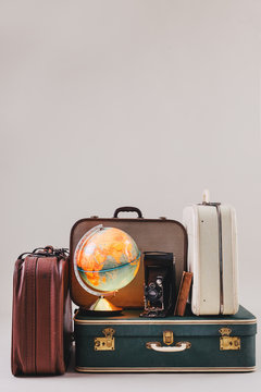 Vintage suitcases with a globe, old camera and antique book.