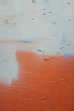 Staples and paint covering graffiti tags on urban wall, close up