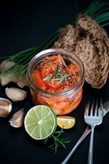Marinated salmon with rosemary and spicy pepper in a glass jar..