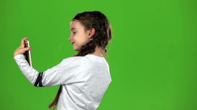 Child does selfie. Green screen. Slow motion