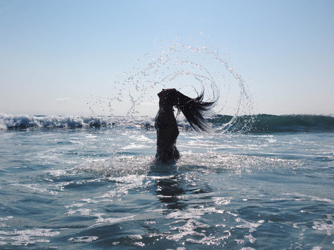 Woman Throwing Hair in Ocean like a Mermaid