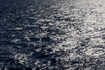 Sea water, the setting sun is reflected in the waves