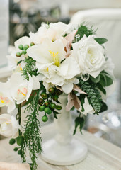 Wedding Table Centerpieces. White floral composition in a white vase.