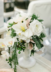 Wedding Table Centerpieces. White floral composition in a white vase.