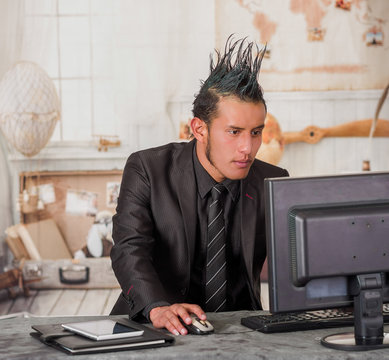Close up of office punk worker wearing a suit with a crest, working in a computer, in a blurred background