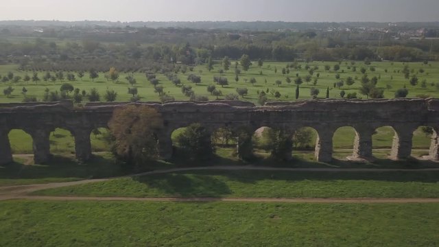Video from above. Aerial view of the ancient Roman Aqueduct. Old ruins surrounded by a green public Park (Parco degli Acquedotti) Rome, Italy.	