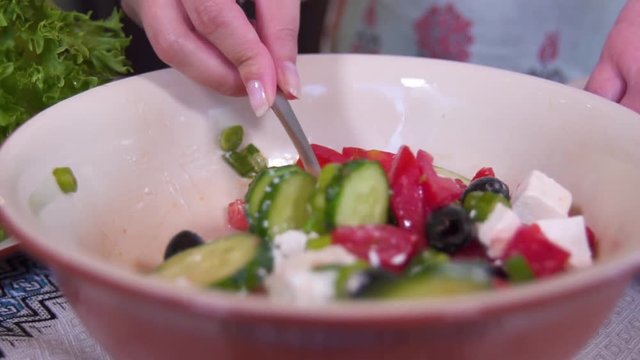 Stirring the Greek salad with butter and cheese