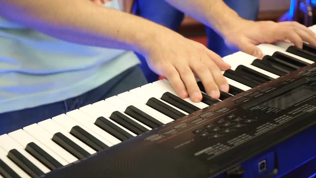 Electric piano, Actor playing on the keyboard synthesizer piano keys. Musician plays a musical instrument on the concert stage. synthesizer, press the keys, man, artist, note