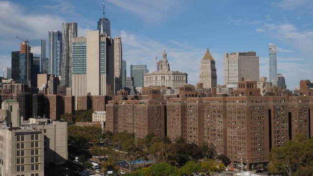 A high angle daytime establishing shot (DX) of the buildings and apartments in Manhattan's Two Bridges neighborhood. The financial district skyline and Freedom Tower in the distance.  	