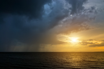 Fototapeta na wymiar Dark Clouds and rain are falling in the sea.