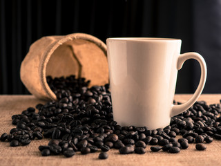 White coffee cup with coffee beans and bag.