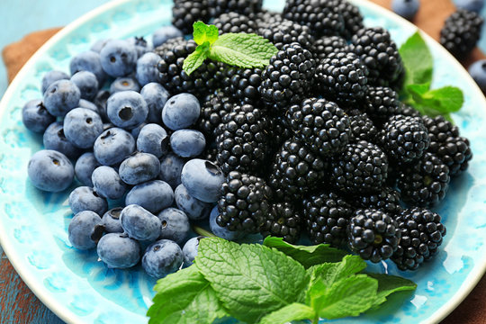 Closeup of delicious ripe blackberries and blueberries on plate