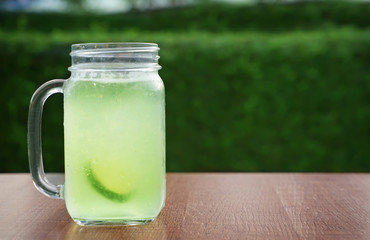 Glass mason jar with fresh drink on table outdoors