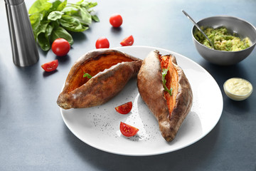 Plate with baked sweet potato on table