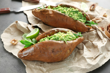 Baked sweet potato stuffed with guacamole on table