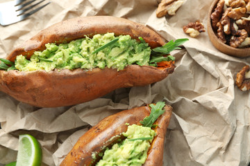 Baked sweet potato stuffed with guacamole on table
