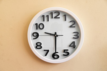 Wall clock on cream color background.
