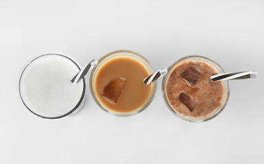 Glasses with protein shakes on white background