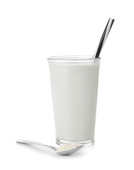 Glass with protein shake and powder in spoon on white background