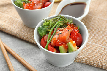 Bowl with delicious salmon salad on table